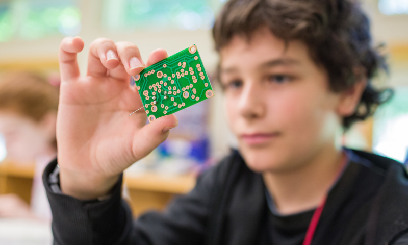 young child looking at computer chip