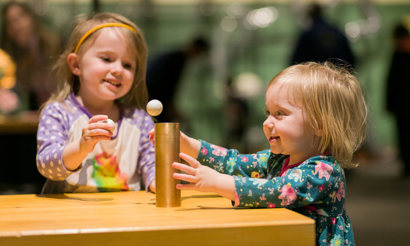 young girl playing with air works table and ball