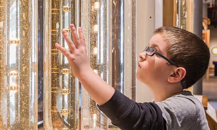 young child looking at sparkly tubes