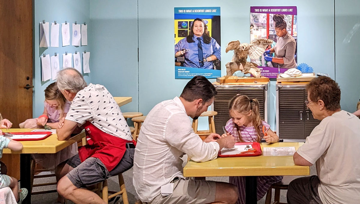 Visitors in the Science Discovery Lab with a Montshire Explainer