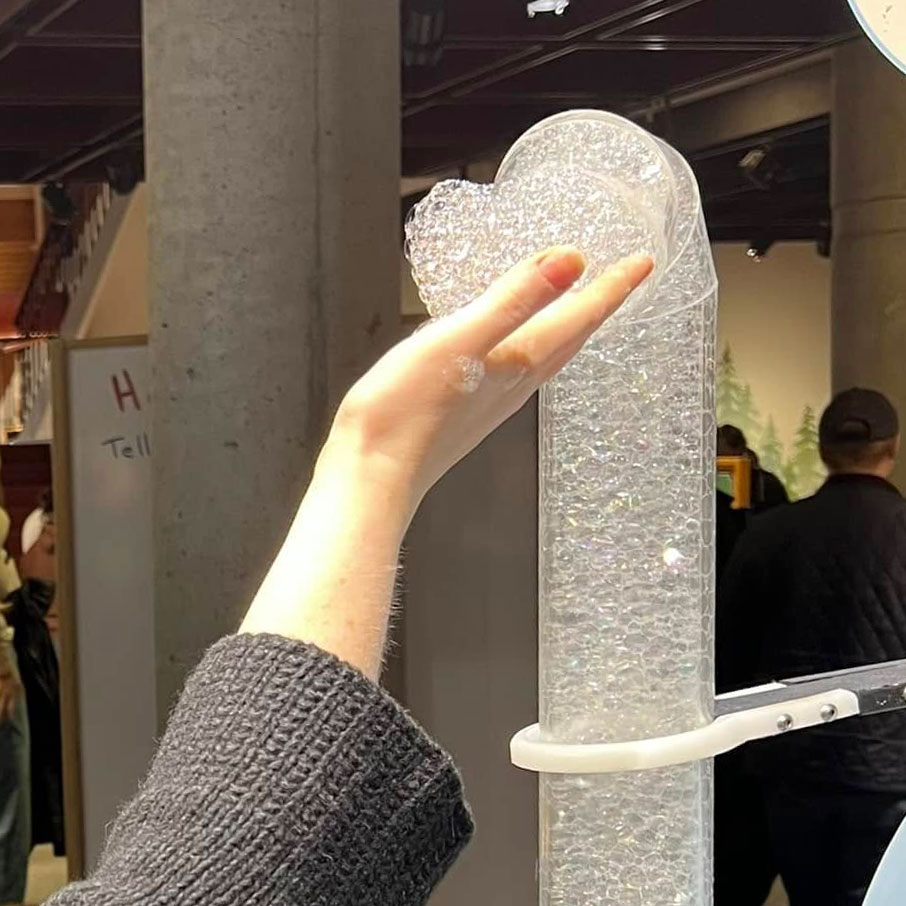 A single hand touching bubbles from a Montshire foam fountain