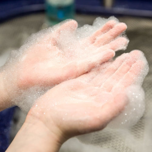 Two hands covered in soap bubble foam