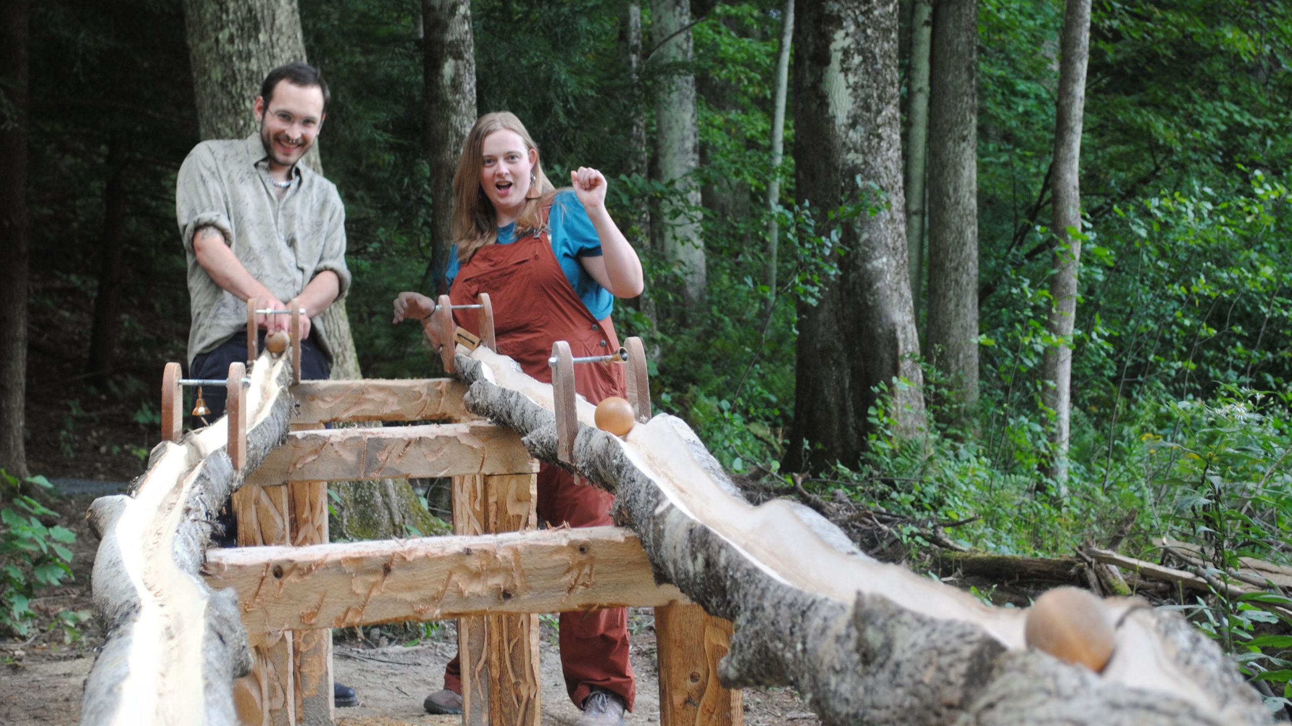 Two adults playing with the Timber Tumble raceway