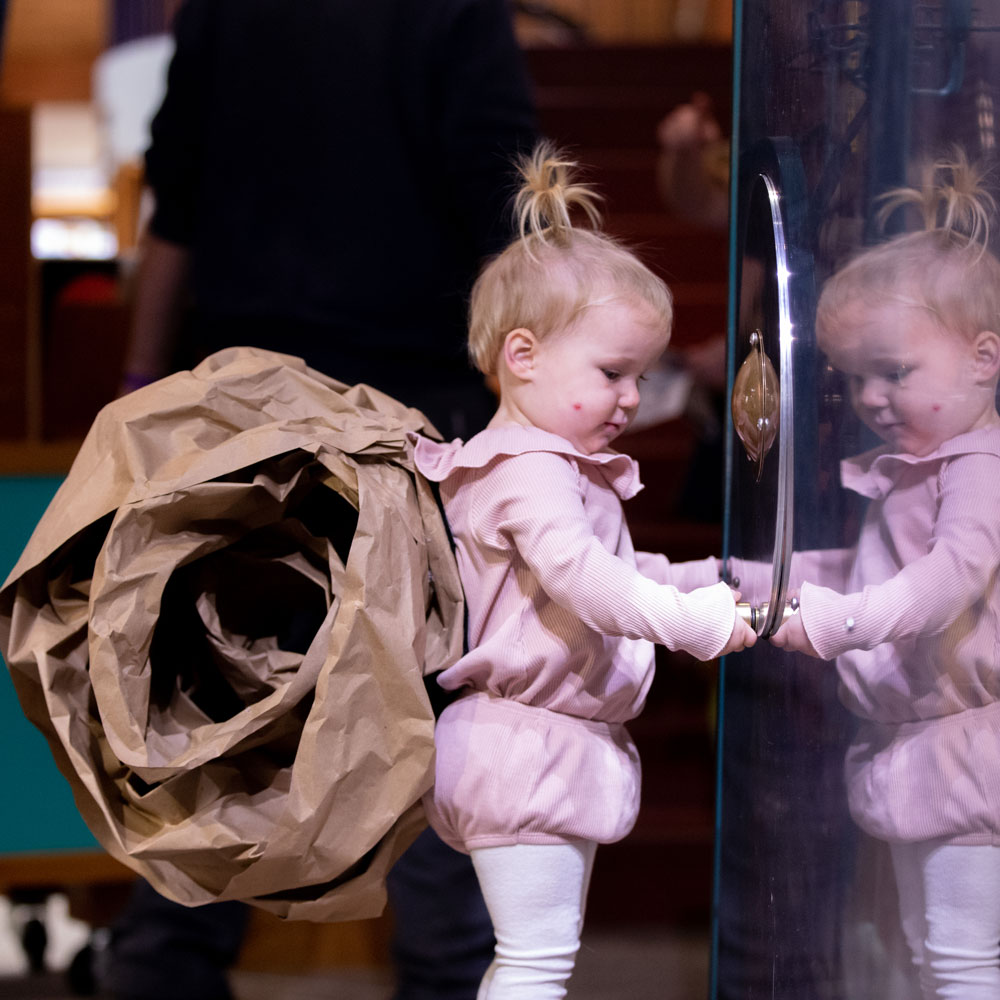 A child in a snail costume at Spooky Science turns a handle on a ball machine