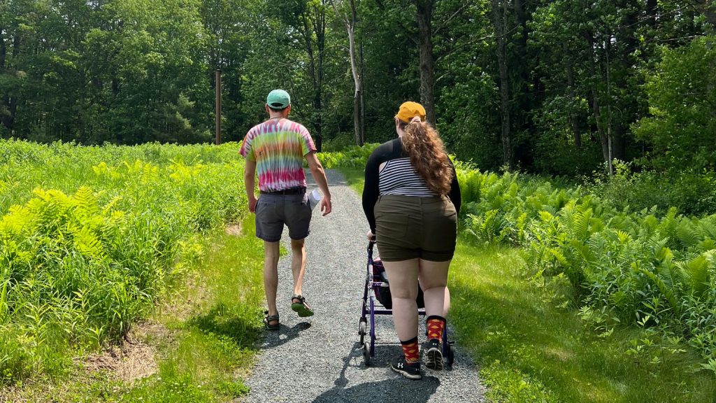 Two adults, one with a wheeled walker, explore the newly resurfaced Meadow Loop trail