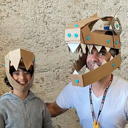A child and an adult wearing toothed cardboard masks